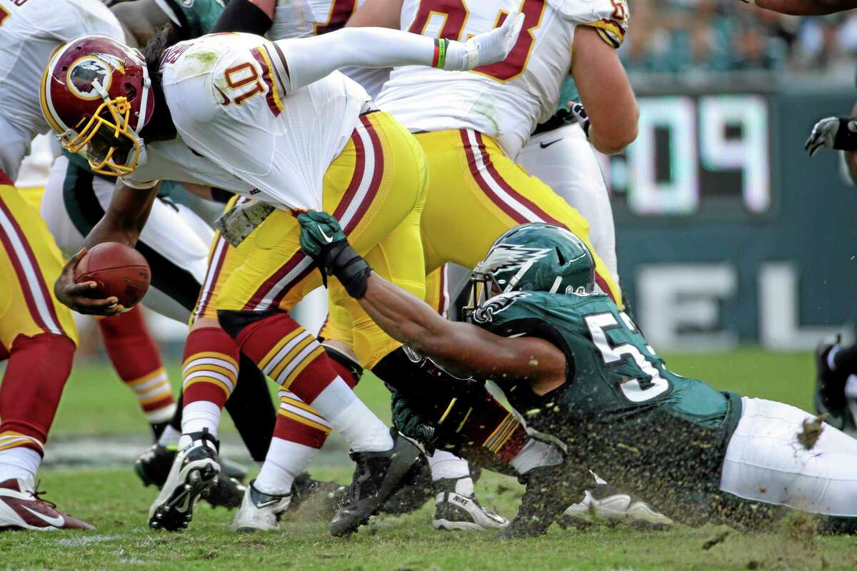 Washington Redskins quarterback Robert Griffin III (10) is dragged to the turf by Philadelphia Eagles linebacker Najee Goode during the first half of an NFL football game in Philadelphia, Sunday, Nov. 17, 2013. (AP Photo/Matt Slocum)