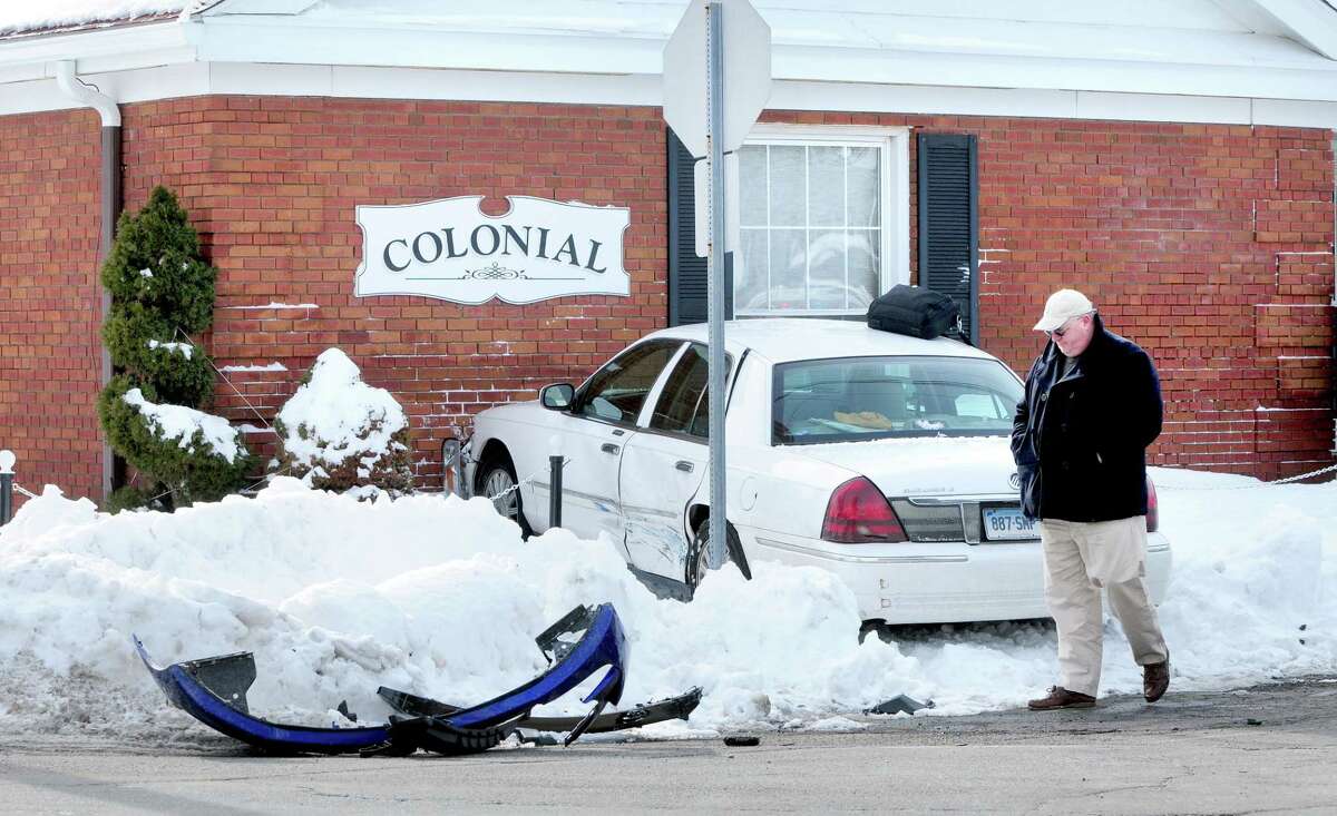 A car ran into Colonial Funerals on the corner of Circular Ave. and Bradley Ave. in Hamden on 2/12/2014. Peter Moraski, owner of Colonial Funerals, thinks it’s a bad intersection and says, “they want drive-in service I guess.” In the foreground is the fender from the other car involved in the accident.