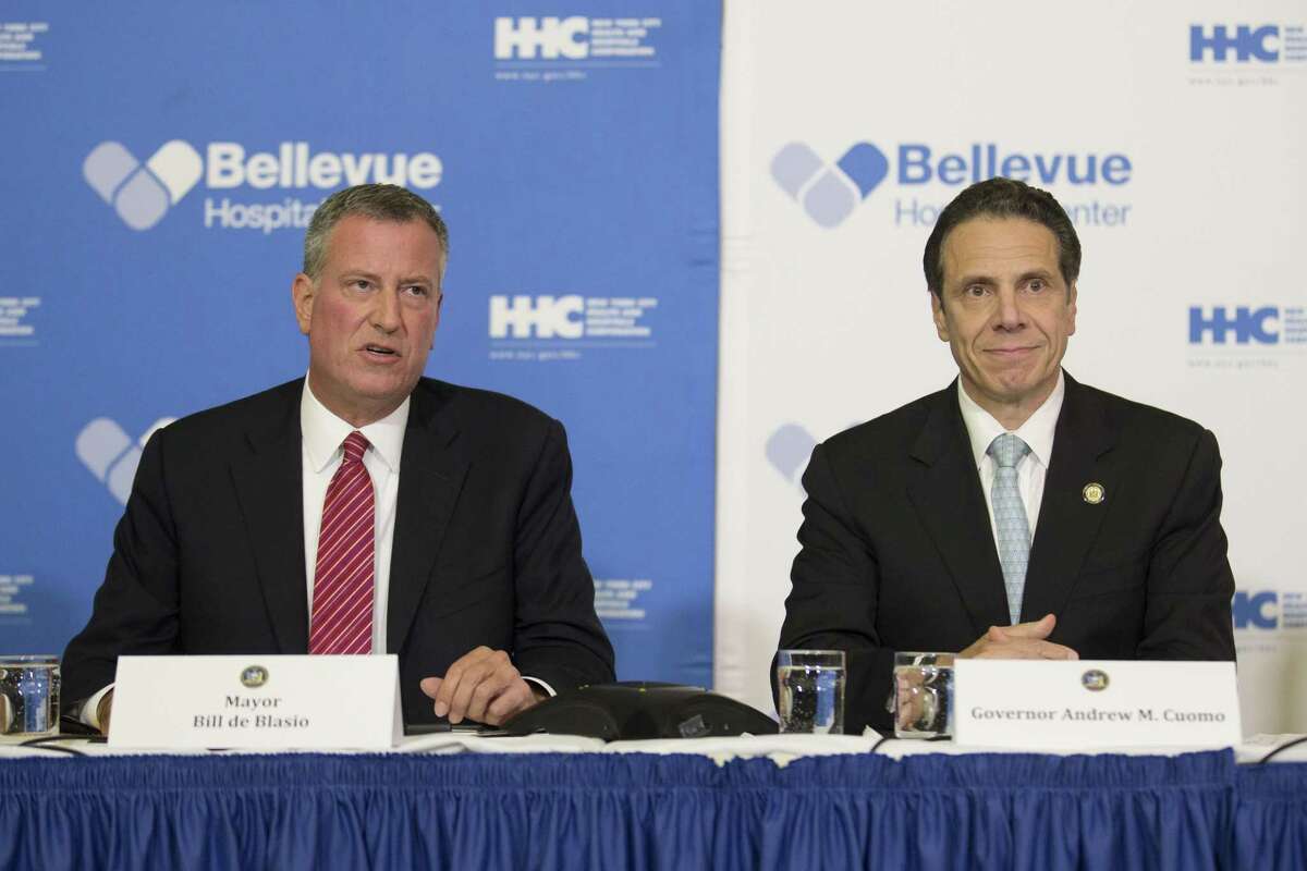 FILE- In this Oct. 23, 1024 file photo, New York City Mayor Bill de Blasio, left, joins New York Gov. Andrew Coumo at a news conference at Bellevue Hospital after New York City physician Dr. Craig Spencer had tested positive for the Ebola virus after returning from West Africa where he treated Ebola patients.
