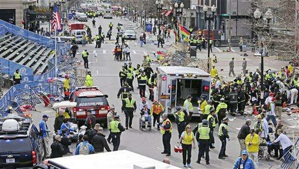 Medical workers aid injured people at the finish line of the 2013 Boston Marathon following explosions in Boston, Monday, April 15, 2013. Two explosions shattered the euphoria of the Boston Marathon finish line on Monday, sending authorities out on the course to carry off the injured while the stragglers were rerouted away from the smoking site of the blasts. (AP Photo/Charles Krupa)