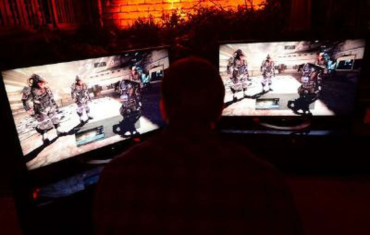 Guests play "Killing Zone - Shadow Fall" on Sony's PlayStation 4 during a pre-launch event for the latest gaming console in New York, November 11, 2013. The PlayStation 4 is set to launch in the US on November 15, 2013.