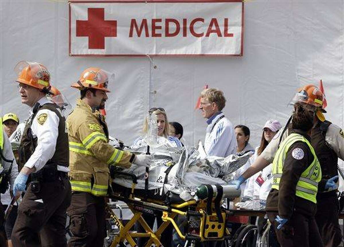 Medical personnel work outside the medical tent in the aftermath of two blasts which exploded near the finish line of the Boston Marathon in Boston, Monday, April 15, 2013. (AP Photo/Elise Amendola)