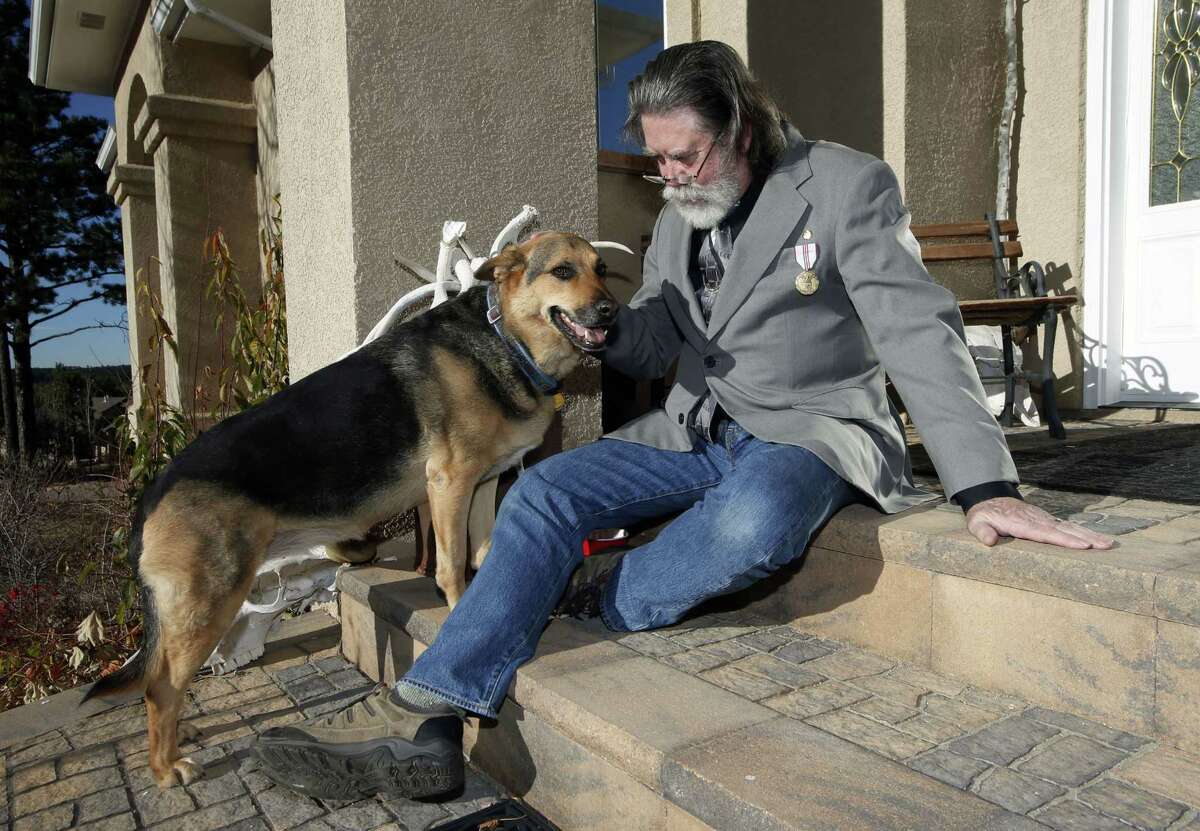 AP Photo/David Zalubowski Robert Curtis poses with his dog, Jasmine, a German Shepherd/Iraeli Canaan mix, at his home, on Thursday, Nov. 6, 2014. A $10 billion-a-year effort to protect sensitive government data, from military secrets to Social Security numbers, is struggling to keep pace with an increasing number of cyberattacks and is unwittingly being undermined by federal employees and contractors. Curtis, according to court records, was besieged by identity thieves after someone stole data tapes that a federal contractor left in a car, exposing the health records of about 5 million current and former Pentagon employees and their families.