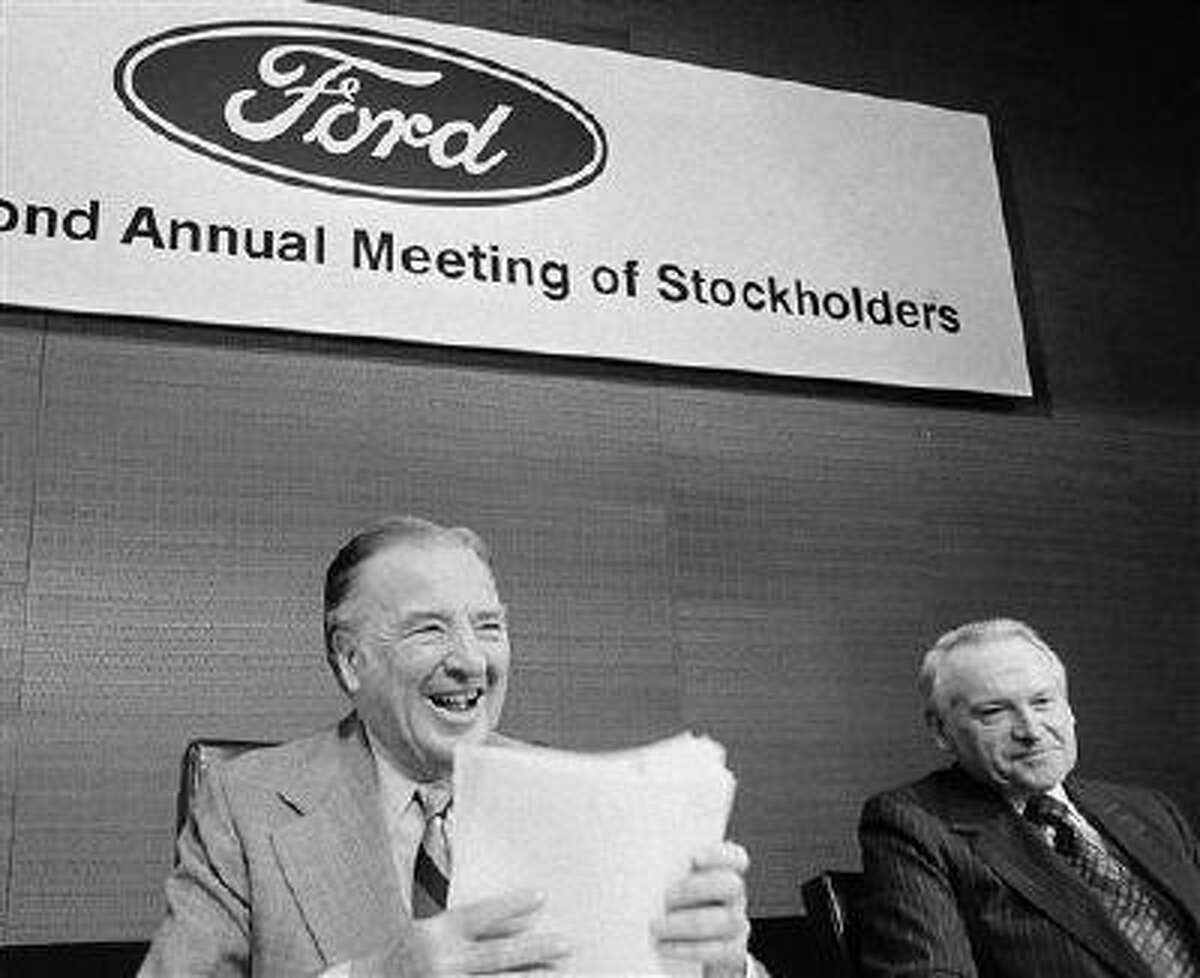 FILE - In a May 12, 1977 file photo, Ford Chairman of the Board Henry Ford II, center, shuffles papers before calling the Ford Motor Company's annual stockholders meeting to order in Detroit. At Ford's left is Philip Caldwell, vice chairman of the board. Cauldwell, the first person to lead Ford Motor Co. who wasn't a member of the founding family, died Wednesday, July 10, 2013 at his home in New Canaan, Conn., at the age of 93. (AP Photo/Richard Sheinwald, File)
