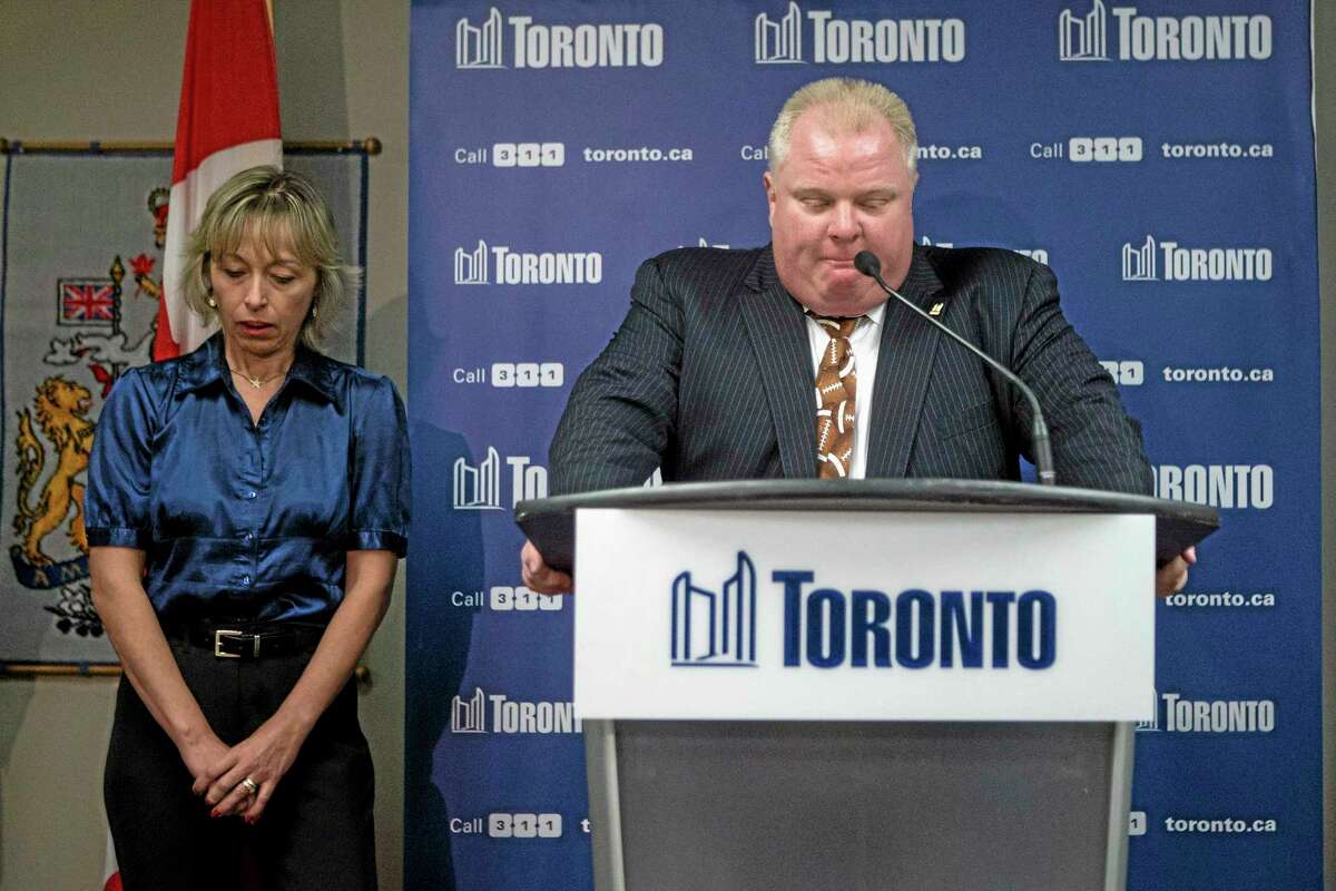 Toronto Mayor Rob Ford stands with his wife Renata at a news conference on Thursday, Nov. 14, 2013. Ford has apologized for making crude comments in responding to allegations contained in court documents. Ford said the "graphic"remarks came after six months of relentless pressure. He said "revelations" of cocaine, escorts and prostitution made public Wednesday had pushed him "over the line." He called the allegations "100 per cent lies." (AP Photo/The Canadian Press, Chris Young)