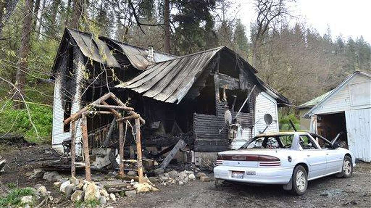 This photo shows the charred remains of a house on Cedar Avenue, Saturday, April 13, 2013 in Orofino, Idaho. An extension cord hooked to an electric grill on a porch shorted out and started a house fire that killed five people Saturday morning, a northern Idaho fire official says. ((AP Photo/Lewiston Tribune, Steve Hanks)