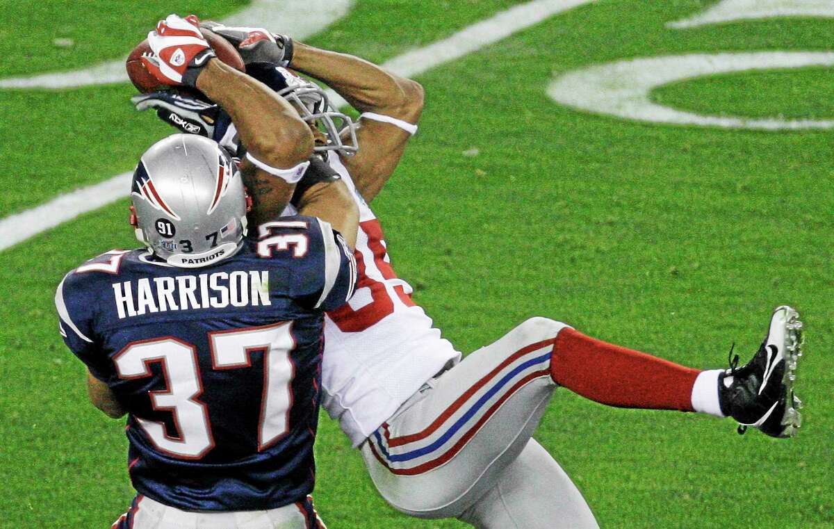 In this Feb. 3, 2008 file photo, New York Giants receiver David Tyree, right, makes a catch against New England Patriots safety Rodney Harrison during the fourth quarter of Super Bowl XLII at University of Phoenix Stadium in Glendale, Ariz.