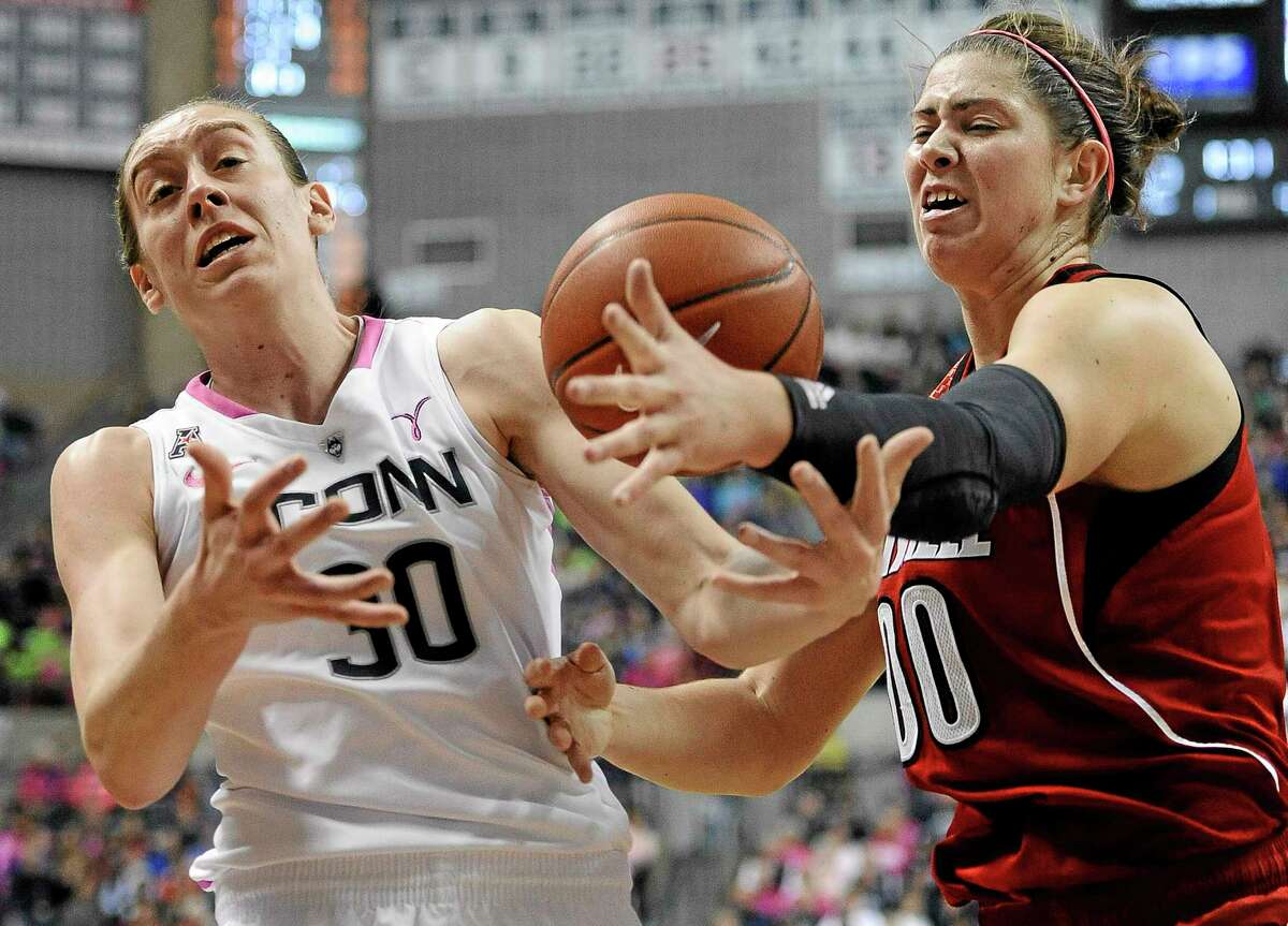 UConn’s Breanna Stewart, left, and Louisville’s Sara Hammond, right, reach for a loose ball during the first half Sunday’s game in Storrs.