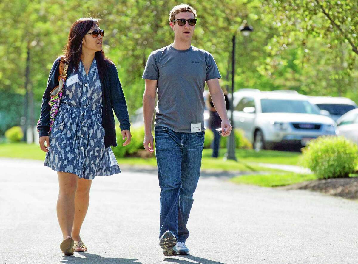 FILE - In this July 9, 2011, file photo, Mark Zuckerberg, president and CEO of Facebook, walks with Priscilla Chan during the 2011 Allen and Co. Sun Valley Conference, in Sun Valley, Idaho. Zuckerberg and his wife, Chan, were the most generous American philanthropists in 2013, The Chronicle of Philanthropy reported, Monday, Feb. 10, 2014, with a donation of 18 million Facebook shares, valued at more than $970 million, given to a Silicon Valley nonprofit in December. (AP Photo/Julie Jacobson, File)