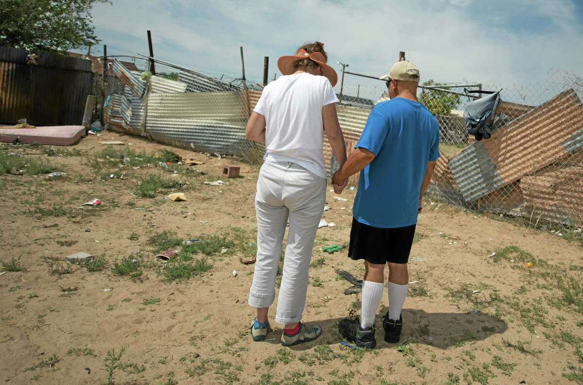 Concerned citizens observe a moment of silence, Monday, July 21, 2014 in the field where two homeless men were bludgeoned to death by teenagers over the weekend near in Albuquerque, N.M. (AP Photo/Albuquerque Journal, Roberto E. Rosales)
