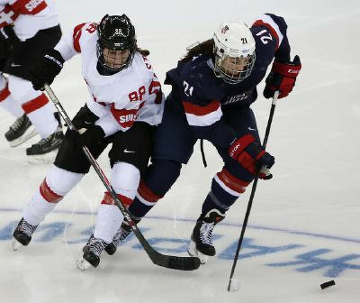 Hilary Knight of the Untied States takes the puck away from Phoebe Stanz of Switzerland during the second period of the 2014 Winter Olympics women's ice hockey game at Shayba Arena, Monday.