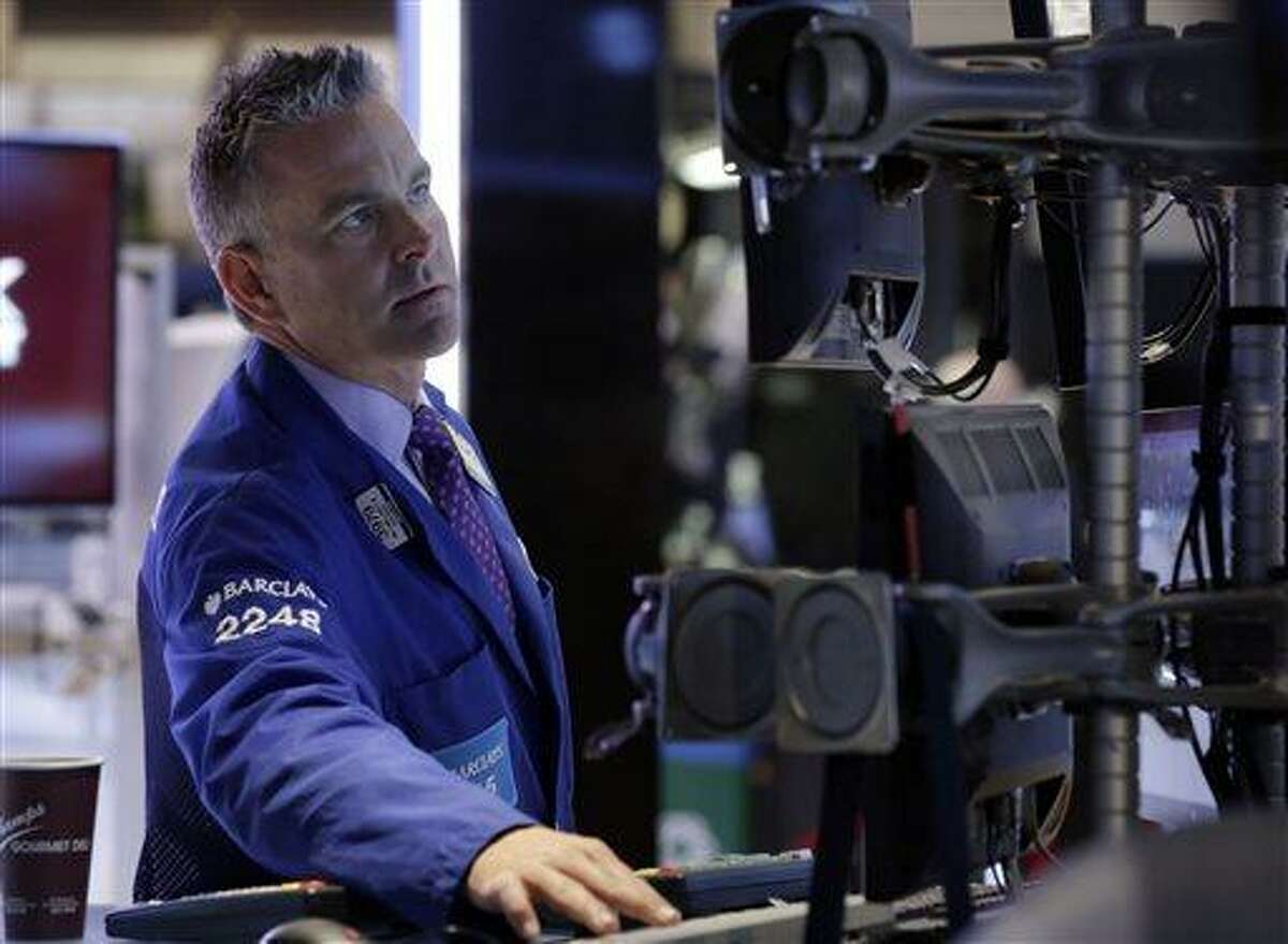 In this Wednesday, July 10, 2013, photo, specialist Christopher Culhane works at his post on the floor of the New York Stock Exchange. Global stocks rose Thursday July 11, 2013 after Federal Reserve chairman Ben Bernanke promised to continue to stimulate the U.S. economy. (AP Photo/Richard Drew)