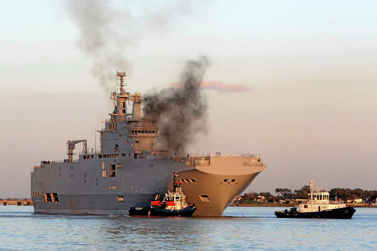 FILE - In this March 5, 2014 file photo, French-built warship BPC Vladivostock, designed to strengthen Russia's ability to deploy troops, tanks and helicopter gunships, leaves the Saint Nazaire's harbor, western France, for its test run on the open sea off coast of France. French President Francois Hollande is defending plans to deliver a 1.1 billion-euro French-made warship to Russia, despite increasing pressure for tougher European sanctions against Moscow over the fighting in Ukraine. European Union foreign ministers are meeting Tuesday July 22, 2014 in Brussels, with some calling for an arms embargo or other new punishment against Russia. (AP Photo/David Vincent, File)