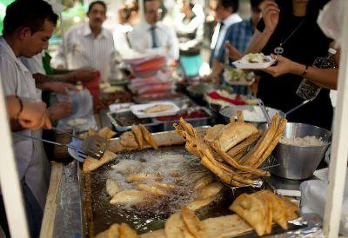 A street vendor fries food for customers during lunch time in Mexico City, Wednesday, July 10, 2013. Mexico has surpassed the United States in levels of adult obesity. Almost one-third of adult Mexicans, 32.8 percent, are obese compared to 31.8 percent of Americans, according to the U.N. Food and Agriculture Organization, or FAO. (AP Photo/Ivan Pierre Aguirre)