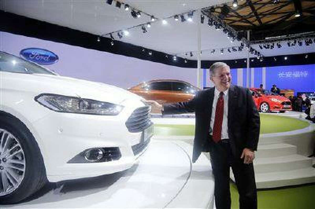 In this photo taken April 20, 2013, David Schoch, Ford Motor Company group vice president and president, Asia Pacific, poses for photos by Ford's new Mondeo car at the Shanghai Auto Show in Shanghai, China. (AP Photo)
