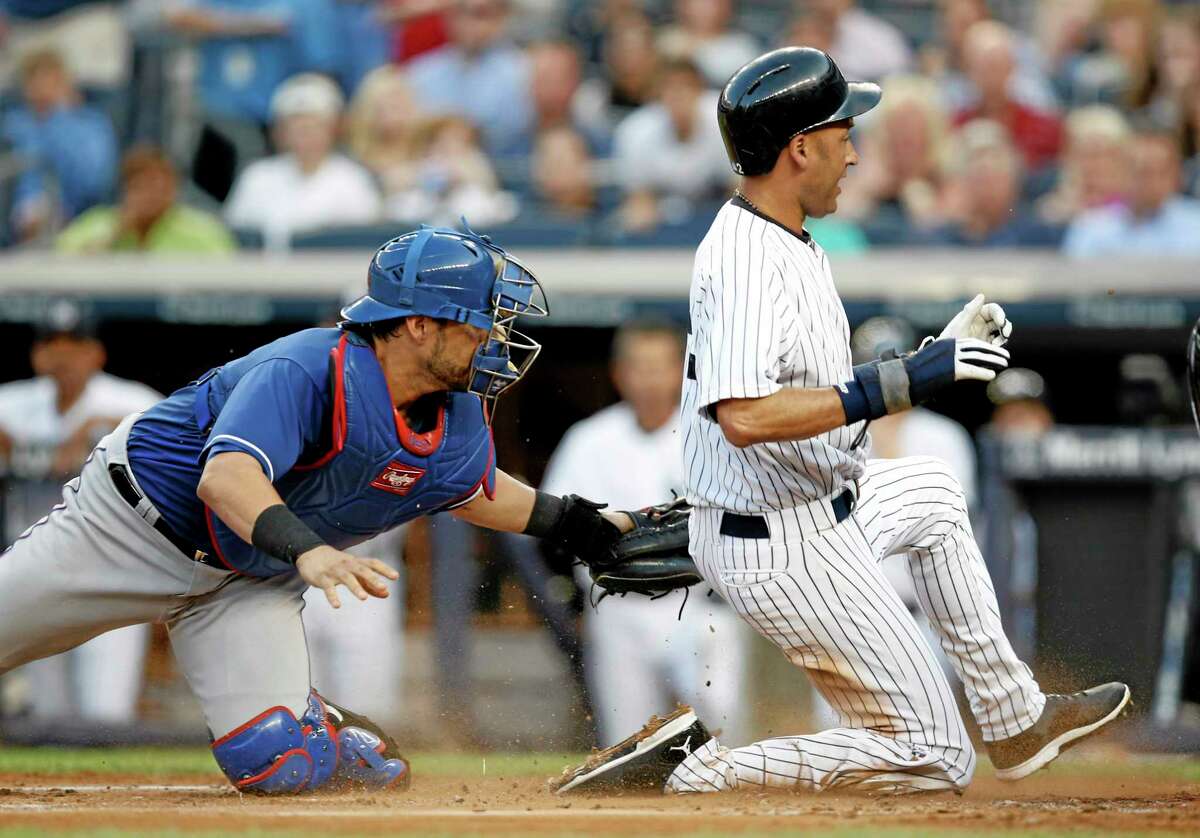 Rangers catcher Geovany Soto attempts to tag Derek Jeter, right, during Monday’s game.