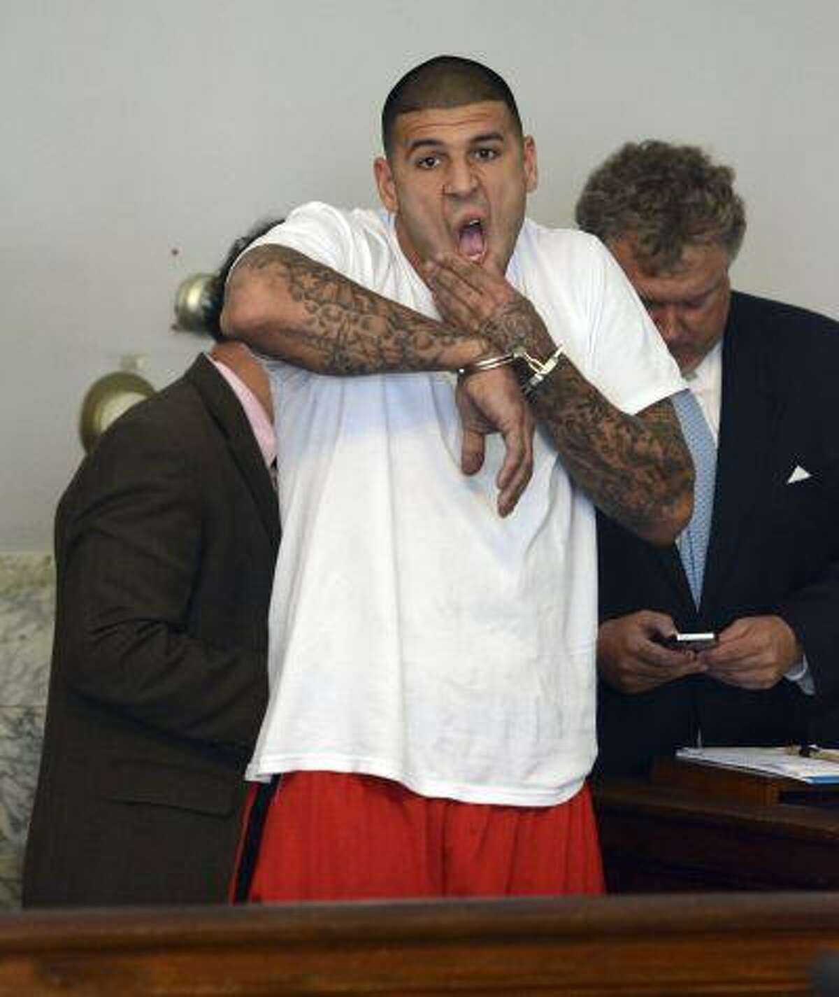 Former New England Patriots tight end Aaron Hernandez, left, stands with his attorney Michael Fee, right, during arraignment in Attleboro District Court Wednesday, June 26, in Attleboro, Mass. Hernandez was charged with murdering Odin Lloyd, a 27-year-old semi-pro football player for the Boston Bandits, whose body was found June 17 in an industrial park in North Attleborough, Mass.