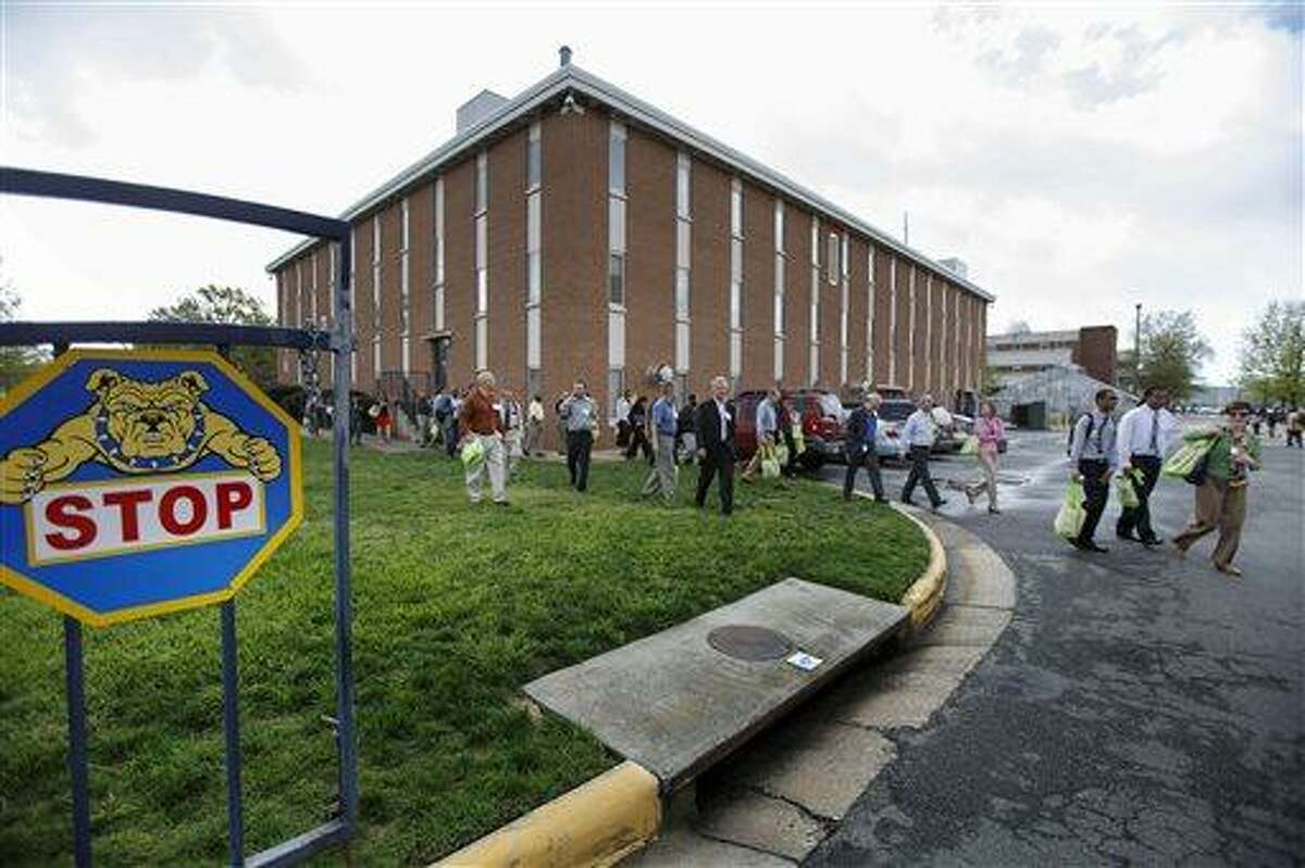 Students and faculty evacuate the North Carolina A&T State University campus at Drew Drive after a person reported seeing a man possibly with a rifle on the campus, Friday, April 12, 2013, in Greensboro, N.C. The university updated its website Friday morning to advise that students should stay inside and lock their doors and windows. (AP Photo/News & Record, Jerry Wolford)
