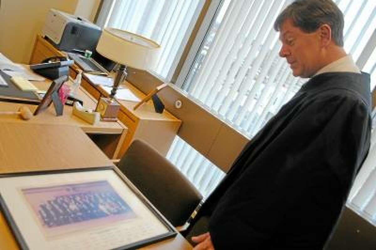 Andrew Roraback, former Connecticut state senator of Goshen, looks at a picture of the Connecticut State Senate Judiciary Committee of 1995-1996. Jessica Glenza/Register Citizen