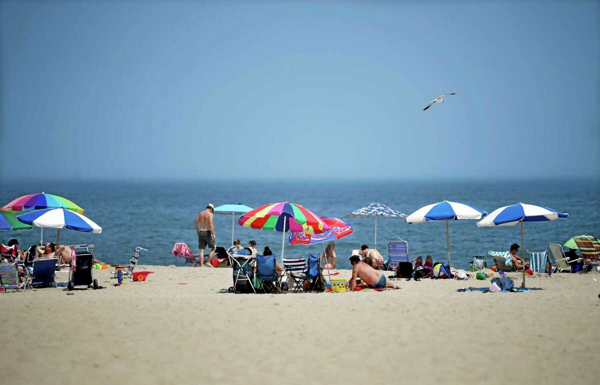Early arrivals relax on the beach Thursday, July 3, 2014, in Point Pleasant Beach, N.J., at the start of the July 4th weekend. (AP Photo/Mel Evans)