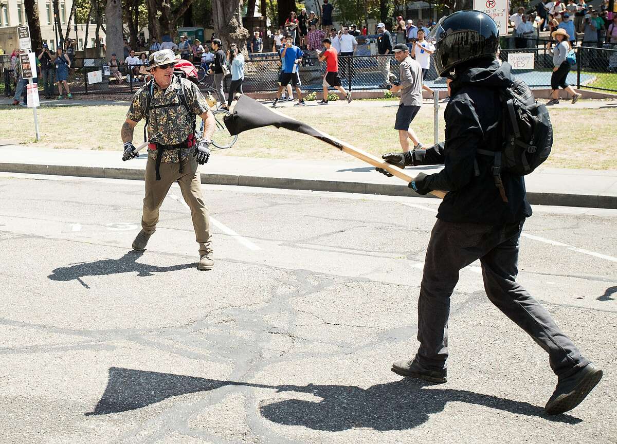 A black bloc protester approaches a conservative demonstrator in Martin Luther King Jr. Civic Center Park on Sunday, Aug. 27, 2017, in Berkeley. The conservatives had planned a "No Marxism in America" gathering.
