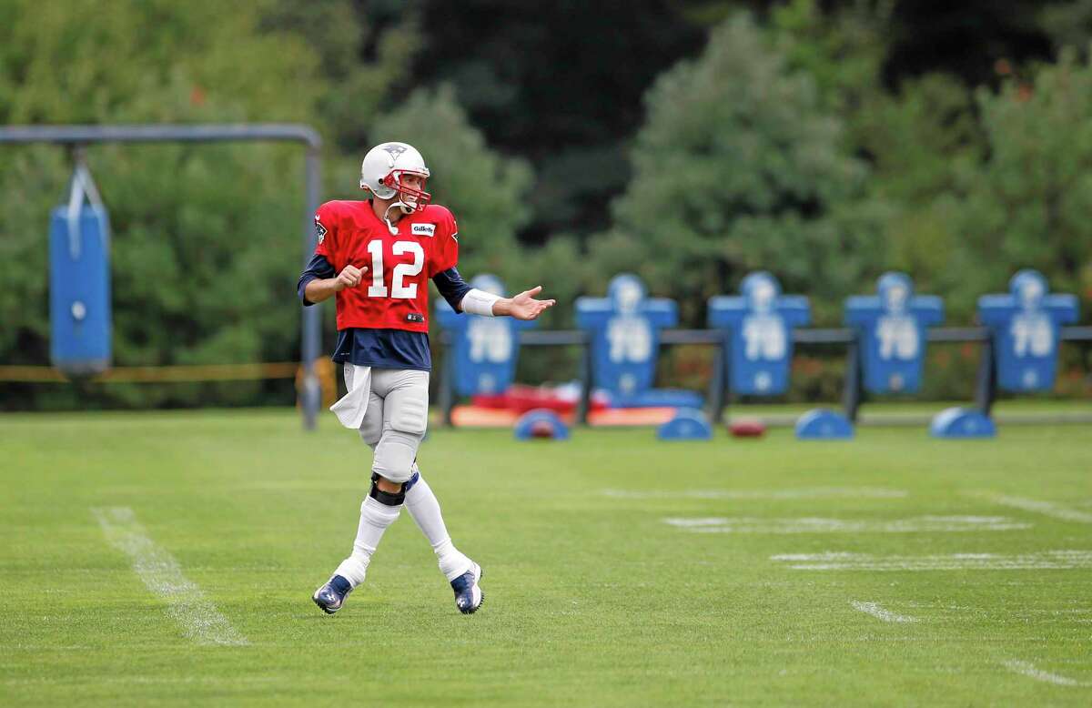 New England Patriots quarterback Tom Brady laughs as he warms up during team football practice in Foxborough, Mass., on Monday.