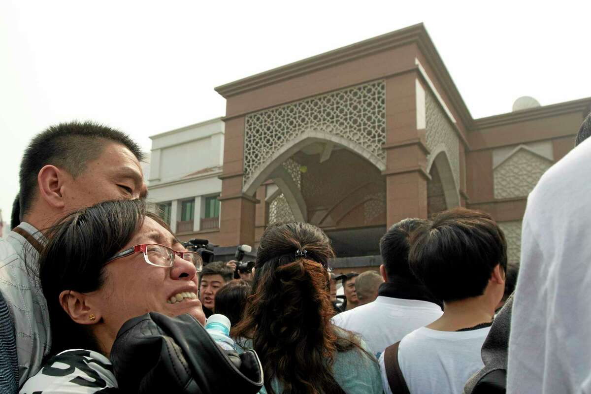 A relative of Chinese passengers onboard the Malaysia Airlines plane breaks down as she protests outside the Malaysian embassy in Beijing, China, Tuesday, March 25, 2014. Furious that Malaysia has declared their loved ones lost in a plane crash without physical evidence, Chinese relatives of the missing marched Tuesday to the Malaysia Embassy, where they threw plastic water bottles, tried to rush the gate and chanted, "Liars!" (AP Photo/Ng Han Guan)