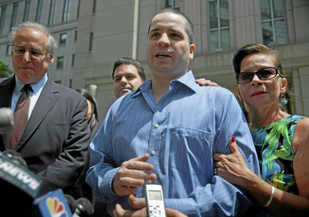 GIlberto Valle, center, makes a short statement to the assembled media as he leaves Manhattan federal court in New York, Tuesday, July 1, 2014. A federal judge has overturned the conviction of Valle, a former New York City police officer accused of plotting to kidnap, kill and eat young women. Valle's mother, Elizabeth Valle is at right. (AP Photo/Seth Wenig)