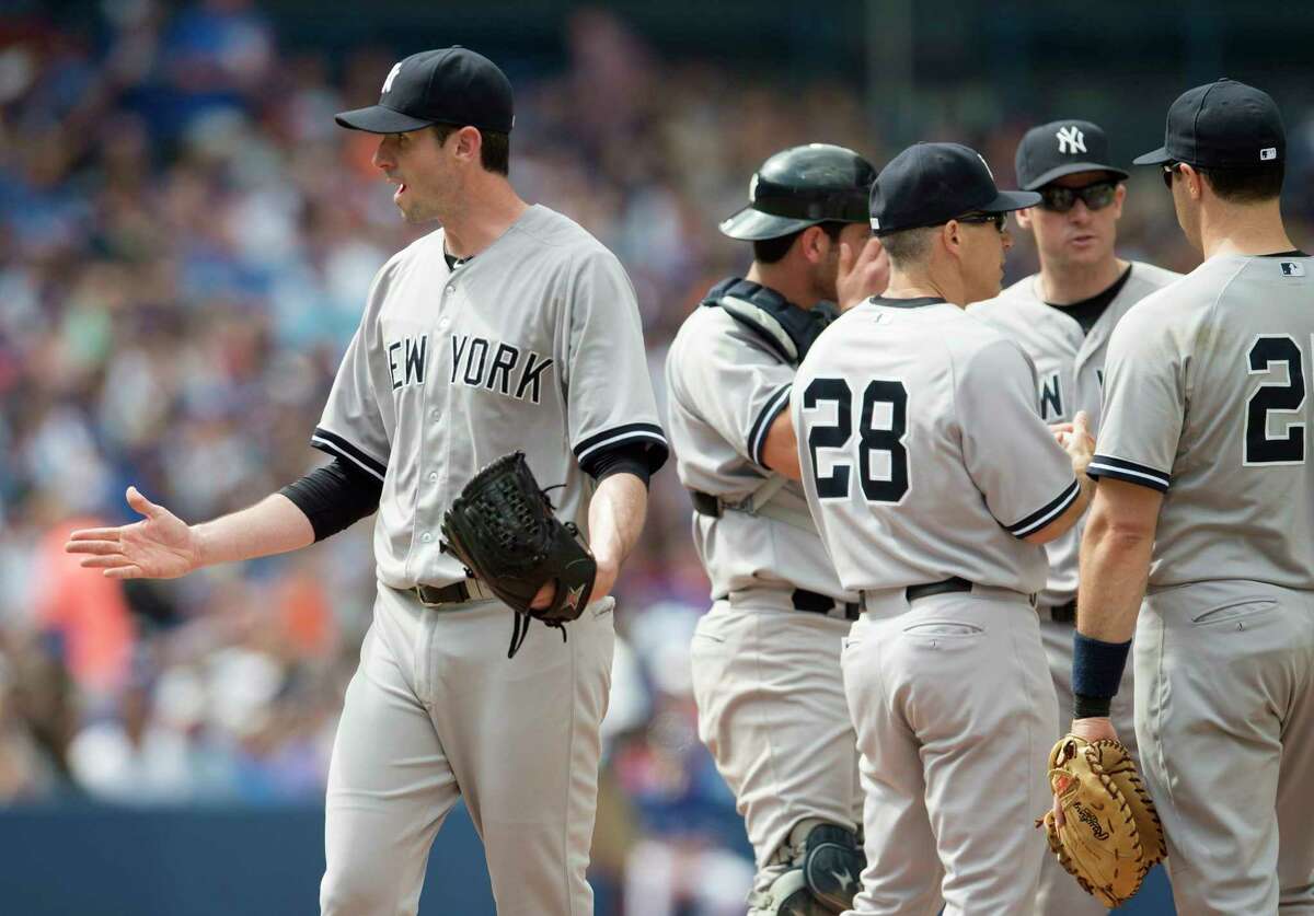 New York Yankees starting pitcher Brandon McCarthy, left, gestures toward home plate umpire Chad Fairchild after being pulled in the seventh inning Sunday.