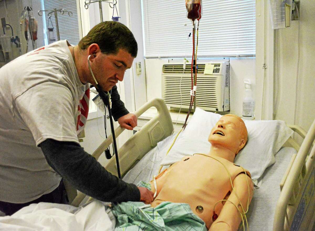 Baras Lebovitz, a student from Woodhall School, how a high-tech mannequin simulates a real patient at Charlotte Hungerford Hospital in Torrington.