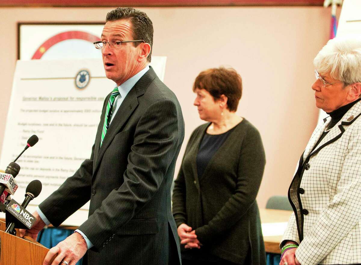 (Photo by Peter Hvizdak ó New Haven Register) ¬ Governor Dannel P. Malloy, with Derby Mayor Anita Duggato, center, and Lt. Governor Nancy Wyman, right, announces a three-point plan for the budget surplus during a press conference Thursday January 30, 2014 at Derby City Hall.