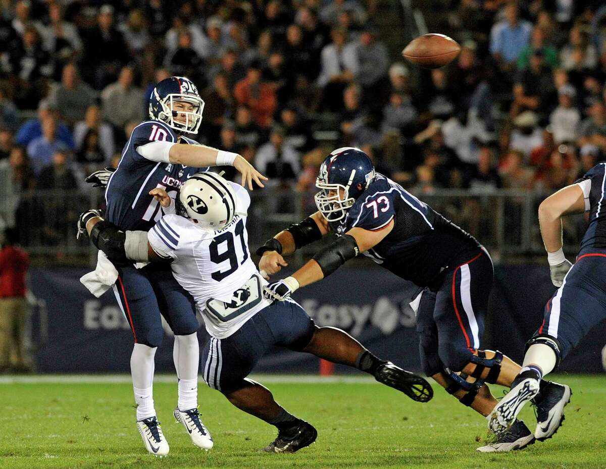 UConn quarterback Chandler Whitmer gets pressured by BYU defensive lineman Travis Tuiloma (91) during the first half of the Huskies’ 35-10 loss on Friday night at Rentschler Field in East Hartford.