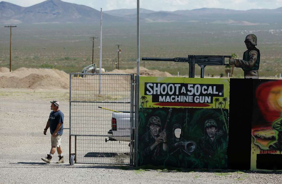 A man closes off an entrance to the Last Stop outdoor shooting range Wednesday, Aug. 27, 2014, in White Hills, Ariz. Gun range instructor Charles Vacca was accidentally killed Monday, Aug. 25, 2014 at the range by a 9-year-old with an Uzi submachine gun.
