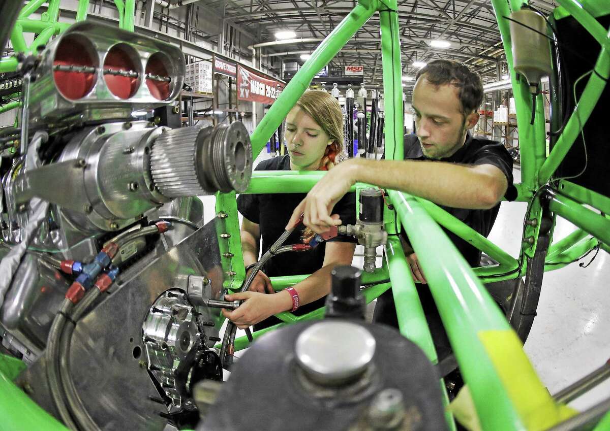 Lauren Dorgan, left, and Cory McGee work on an engine of a monster truck at Feld Entertainment in Ellenton, Fla.