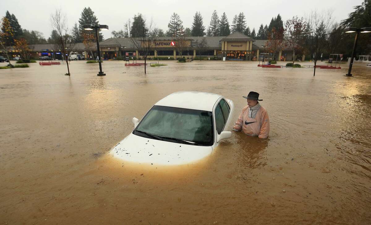 A resident of Guerneville, Calif., who parked his car overnight in the Safeway parking lot on Vine Street in Healdsburg, Calif., finds it nearly completely submerged as Foss Creek topped it's banks, Thursday morning, Dec. 11, 2014. A powerful storm churned down the West Coast Thursday, bringing strong gales and much-needed rain and snow that caused widespread blackouts in Northern California and whiteouts in the Sierra Nevada. Sonoma County authorities are recommending hundreds of people evacuate the lowest lying areas near the Russian River, which is projected to start overflowing overnight. (AP Photo, The Press Democrat, Kent Porter)