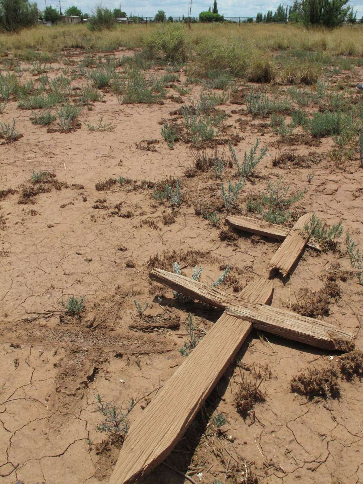 This July 9, 2014 photos shows wooden crosses lying in a dusty cemetery in Winslow, Arizona. Local historic preservation Commissioner Gail Sadler has made it her mission to unearth the identities of roughly 600 people buried there and help their descendants reconnect with a lost part of their history. (AP Photo/Felicia Fonseca)