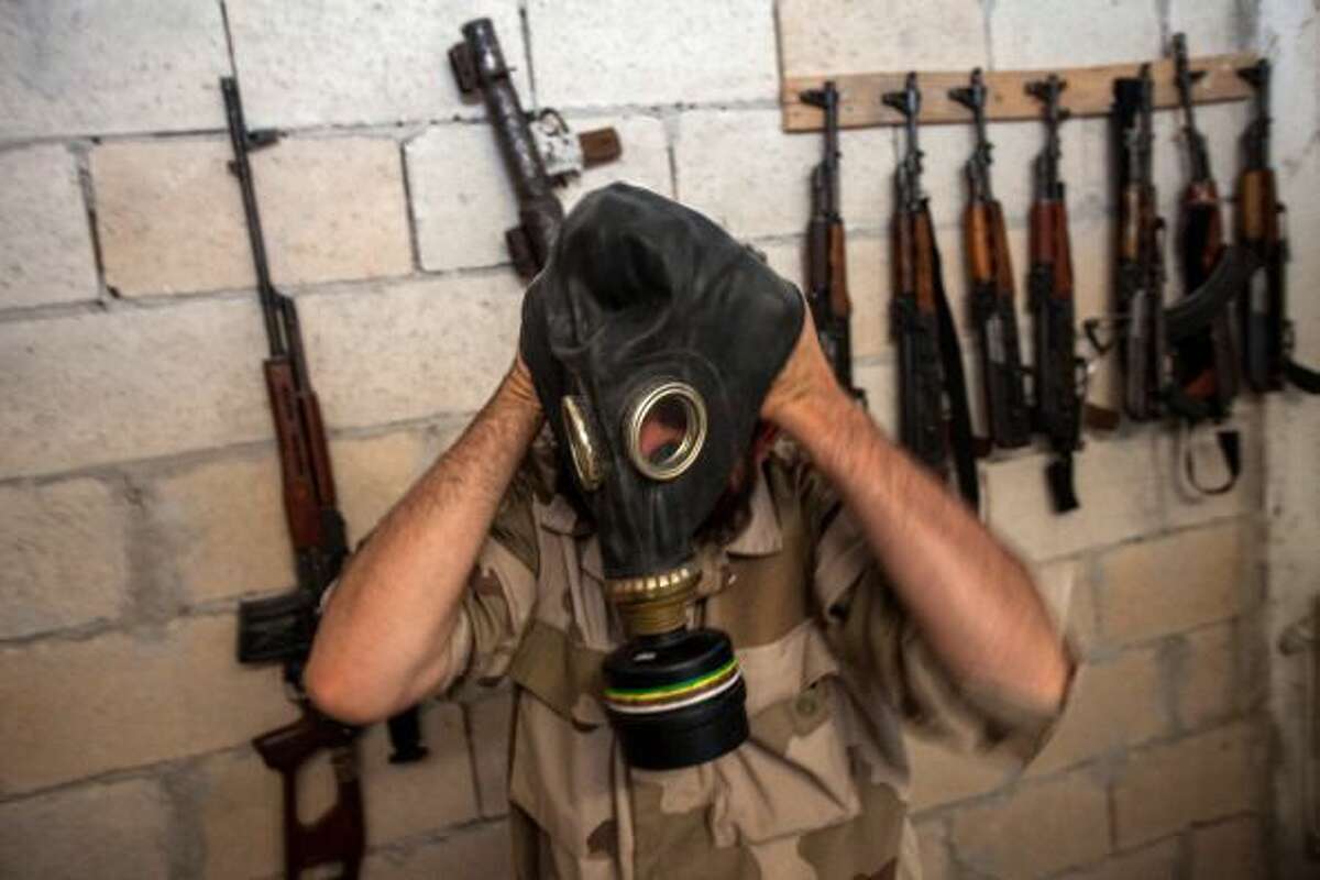 A Syrian rebel tries on a gas mask seized from a Syrian army factory in the northwestern province of Idlib on July 18. (Daniel Leal-Olivas/AFP/Getty Images)