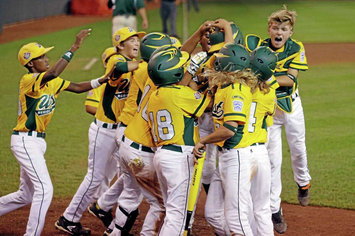 Chula VIsta, Calif.'s Grant Holman is swarmed by celebrating teammates after hitting a three-run home run off Westport, Conn., pitcher Max Popken in the ninth inning of a baseball game at the Little League World Series in South Williamsport, Pa., Wednesday, Aug. 21, 2013. Chula Vista won 6-3. (AP Photo/Gene J. Puskar)