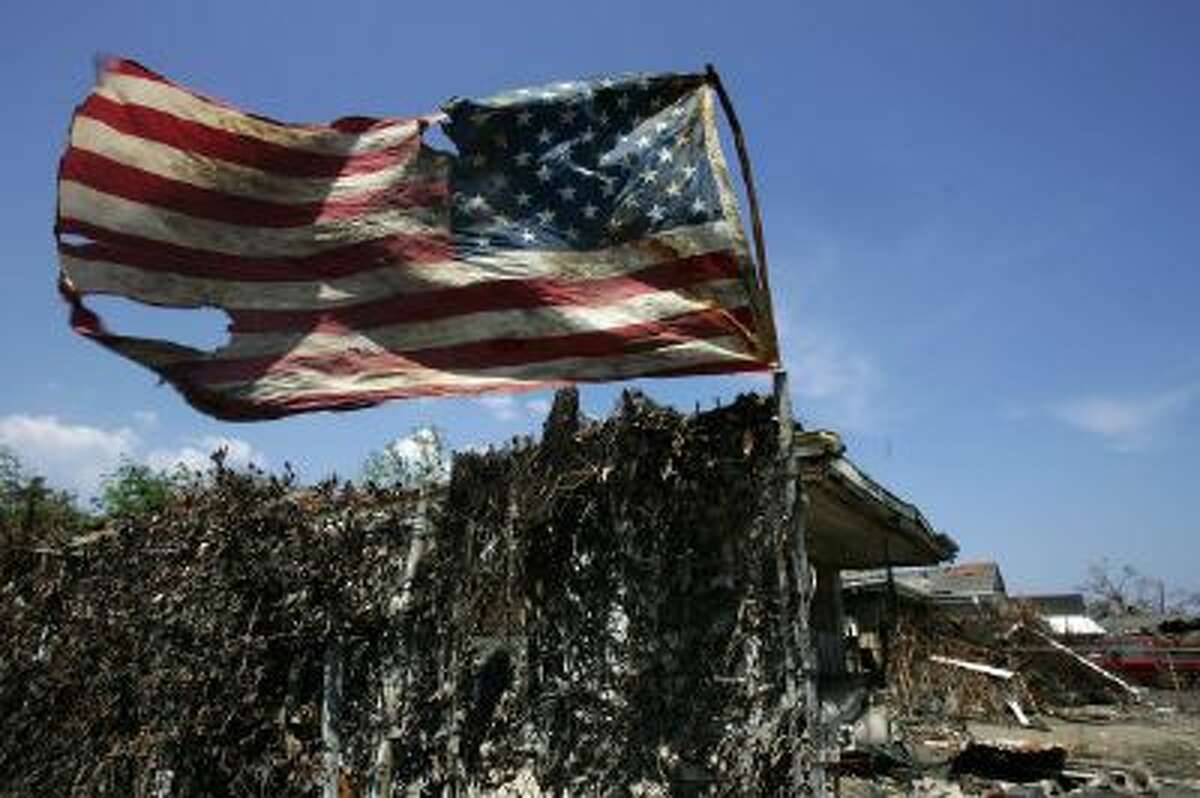 A tattered US flag waves on a pole in the devastated Ninth Ward of New Orleans on Sept. 21, 2005, following Hurricane Katrina.