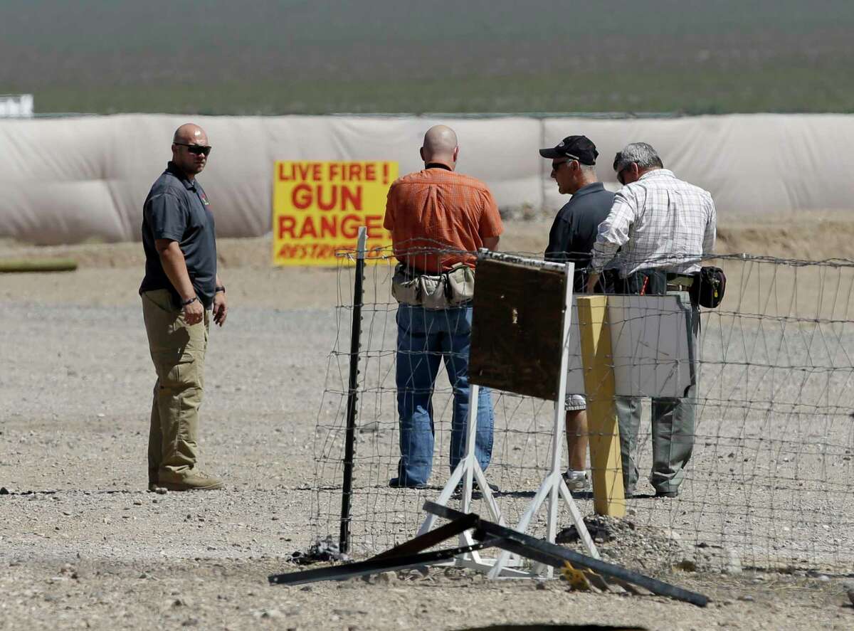 People are seen at the Last Stop outdoor shooting range Wednesday, Aug. 27, 2014, in White Hills, Ariz. Gun range instructor Charles Vacca was accidentally killed Monday, Aug. 25, 2014 at the range by a 9-year-old with an Uzi submachine gun. (AP Photo/John Locher)