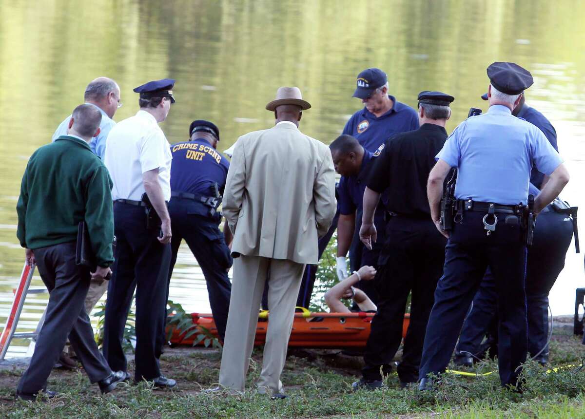 Philadelphia police and other law enforcement officials view a body pulled from the Schuylkill River in Fairmount Park in Philadelphia, Wednesday, Aug. 27, 2014. The bound bodies of two people were found in the river Wednesday, and a third man who said he managed to free himself is being treated at a hospital for stab wounds, police said.