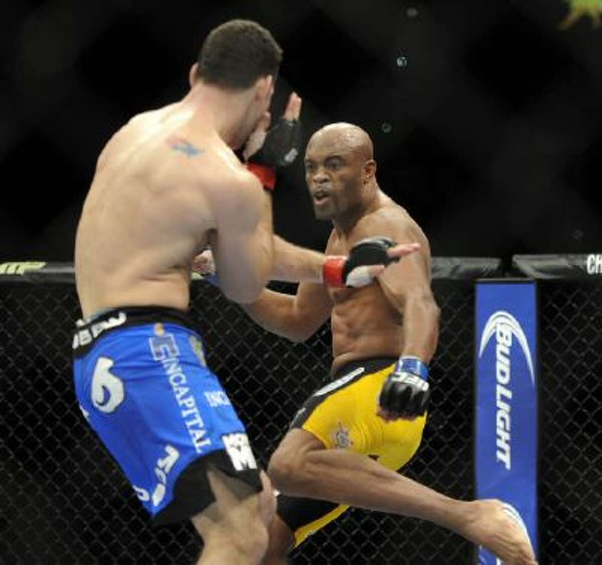 Anderson Silva, right, of Brazil, prepares to kick Chris Weidman of Baldwin, N.Y., during the UFC 168 mixed martial arts middleweight championship bout on Saturday, Dec. 28, 2013, in Las Vegas.