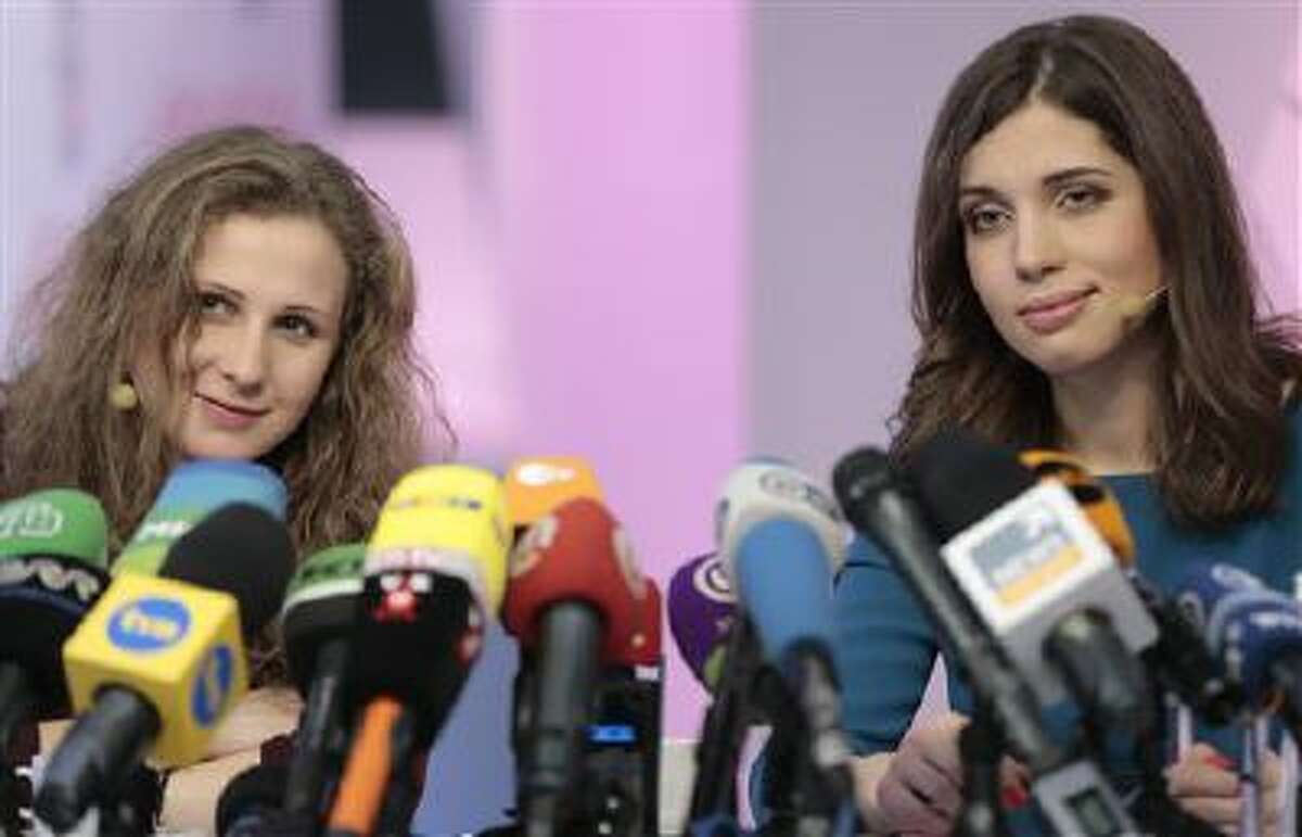 Russian punk band Pussy Riot members Nadezhda Tolokonnikova, right, and Maria Alekhina smile during their news conference in Moscow, Russia, on Friday, Dec. 27, 2013. Tolokonnikova and Alekhina were granted amnesty on Monday, Dec. 23, two months short of their scheduled release after spending nearly two years in prison for their protest at Moscow's main cathedral.