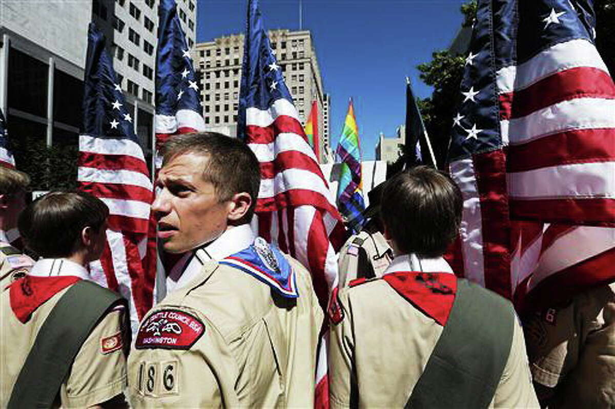 FILE - In this June 30, 2013 file photo, Boy Scouts from the Chief Seattle Council carry U.S. flags as they prepare to march in the Gay Pride Parade in downtown Seattle. The Boy Scouts of America, in the most contentious change of membership policy in a 103-year history, will accept openly gay youths in Scout units starting on New Year's Day 2014. (AP Photo/Elaine Thompson, File)