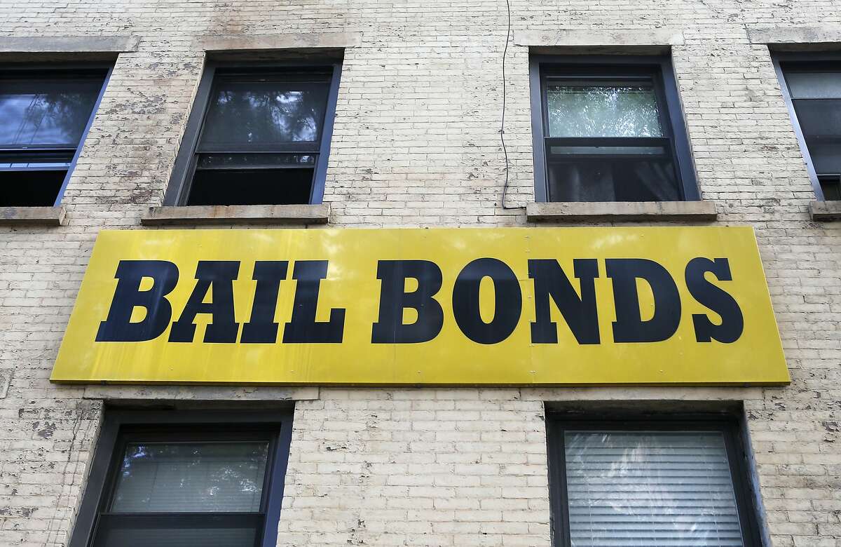 In this photo taken Tuesday, July 7, 2015, a bail bonds sign hangs on the side of a bail bonds business near Brooklyn's courthouse complex and jail in New York. Officials say they�re eliminating cash bail for thousands of New Yorkers accused of misdemeanor and non-violent felonies in an effort to divert them from the Rikers Island jail complex. An $18 million plan to be unveiled Wednesday, July 8, will allow judges to instead require that people accused of certain crimes be monitored while they wait for their trial. (AP Photo/Kathy Willens)