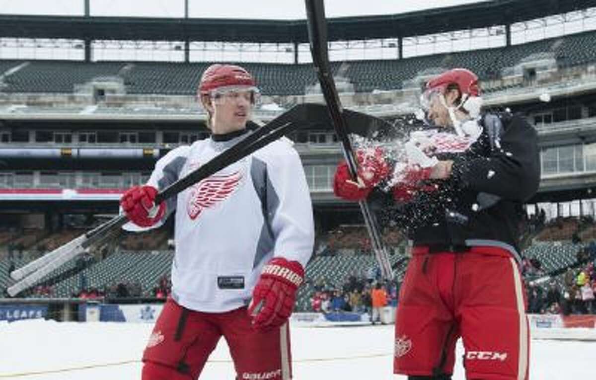 Detroit Red Wings' Justin Abdelkader, left, tosses some snow into the face of teammate Brendan Smith as they walk out onto the ice to the outdoor hockey rink for practice at Comerica Park, home of the Detroit Tigers baseball team, Wednesday, Dec. 18, 2013, in Detroit.