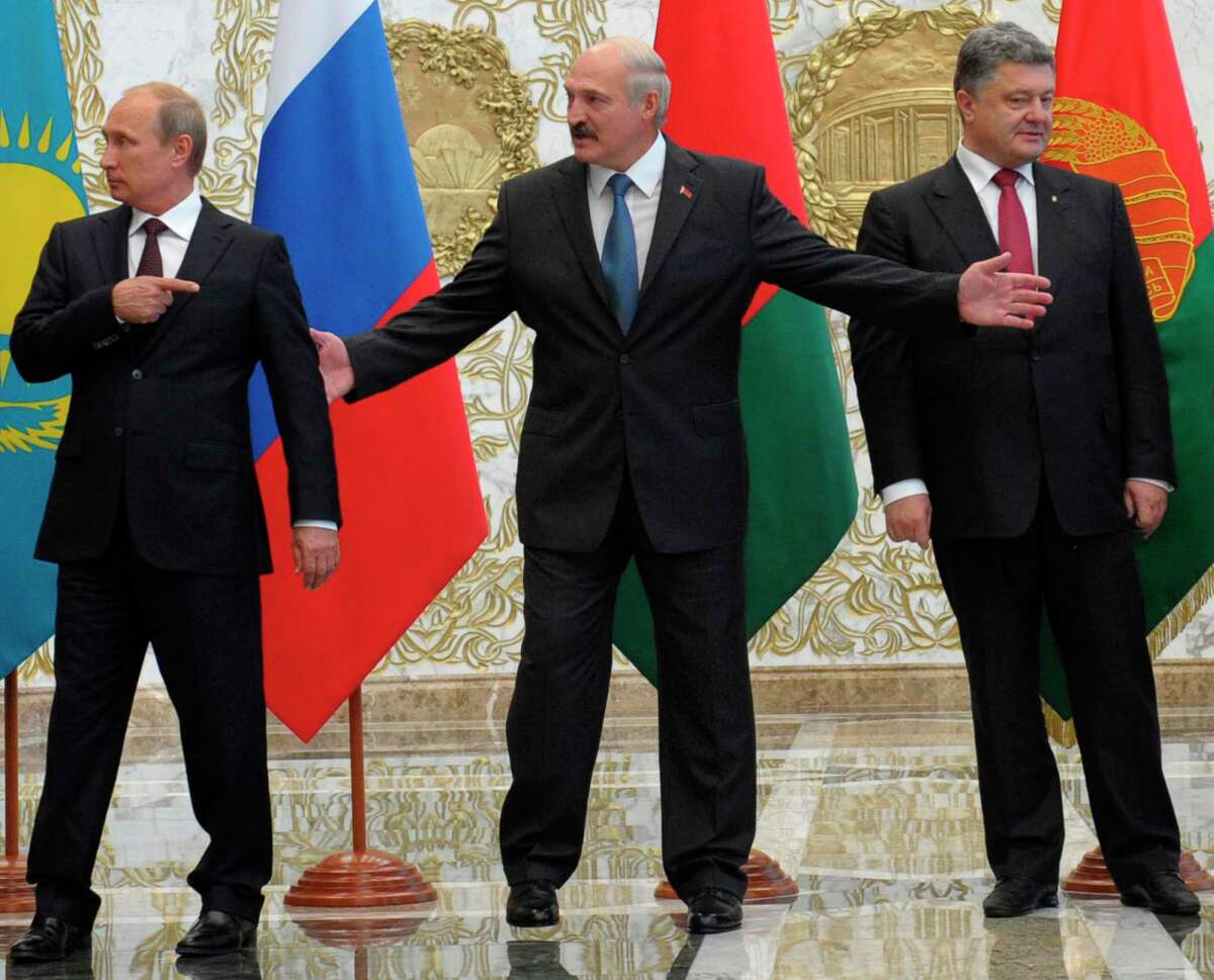 From left, Russian President Vladimir Putin, Belarusian President Alexander Lukashenko and Ukrainian President Petro Poroshenko stand before posing for a photo prior to talks in Minsk, Belarus, Tuesday, Aug. 26, 2014. The presidents of Russia and Ukraine sat down for talks Tuesday, meeting face-to-face for the first time since June on the fighting that has engulfed Ukraine's separatist east. (AP Photo/RIA-Novosti, Alexei Druzhinin, Presidential Press Service)