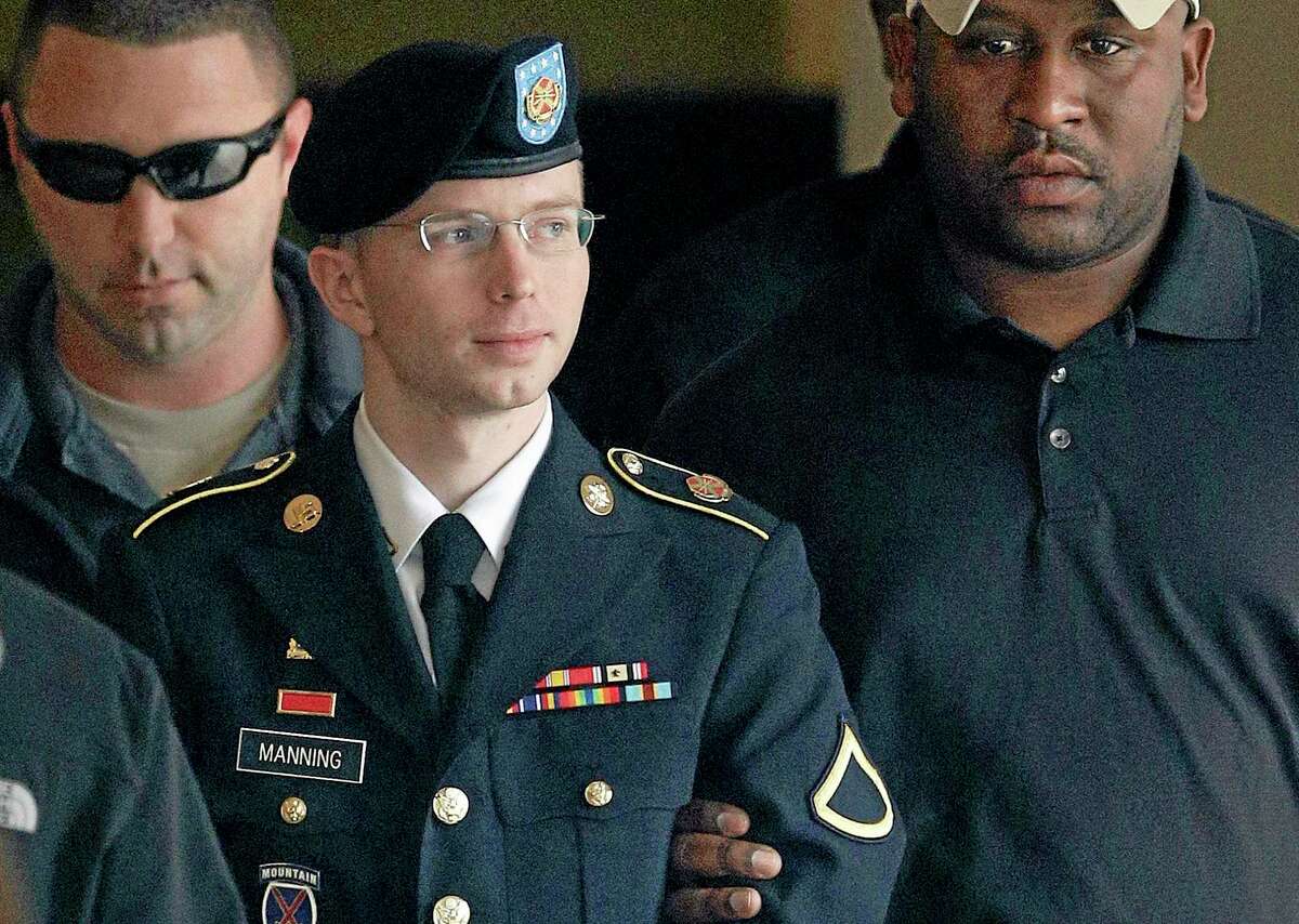 FILE - In this Tuesday, Aug. 20, 2013 file photo, Army Pfc. Bradley Manning is escorted to a security vehicle outside a courthouse in Fort Meade, Md., after a hearing in his court martial. On Wednesday, Aug. 21, 2013, Manning was sentenced to 35 years in prison for leaking a trove of classified information to the anti-secrecy website WikiLeaks. (AP Photo/Patrick Semansky, File)
