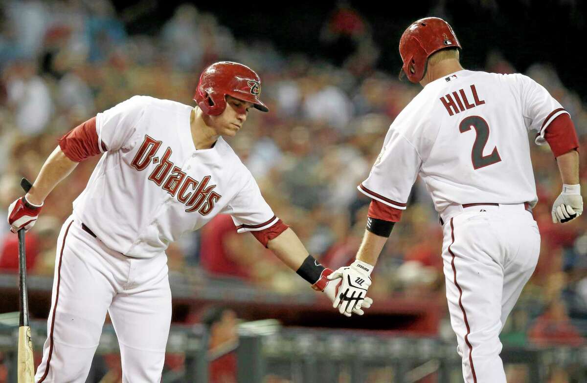 The Arizona Diamondbacks’ Aaron Hill (2) celebrates his home run with teammate Miguel Montero, left, during a July 22 game in Phoenix.