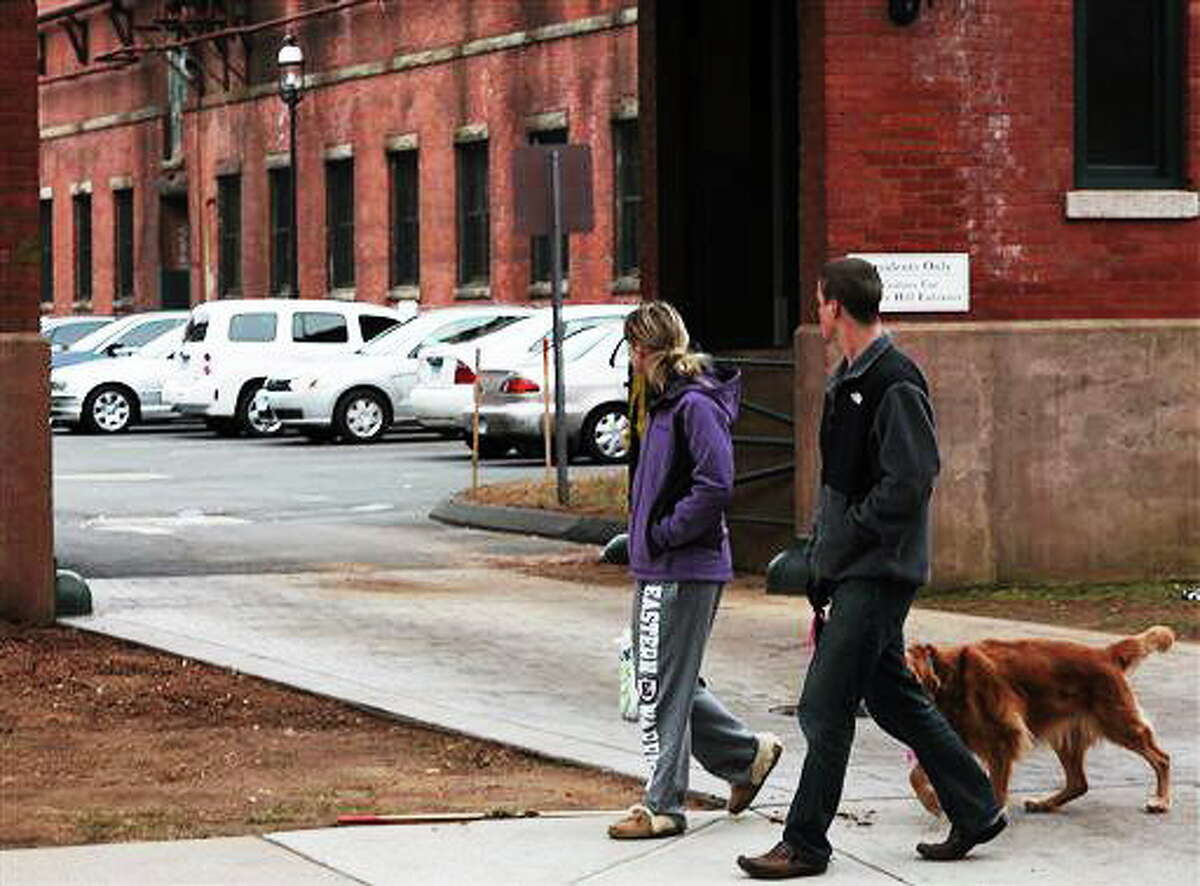Neighbors walk by the scene where a triple murder-suicide occurred on Sunday, Dec. 8, 2013 in Manchester, Conn. A triple murder-suicide that occurred late Saturday evening at the Dye House Apartments is being investigated by the Manchester Police Department and the Connecticut State Police. Officers received reports of shots fired near 190 Pine Street at 9:40pm on . Police quickly responded and confronted a man in a parking lot carrying a 13 month old child. The man then placed the child on the ground and shot himself. Three women were discovered in one unit in the building dead from apparent gunshot wounds. (AP Photo/Journal Inquirer, Jared Ramsdell)
